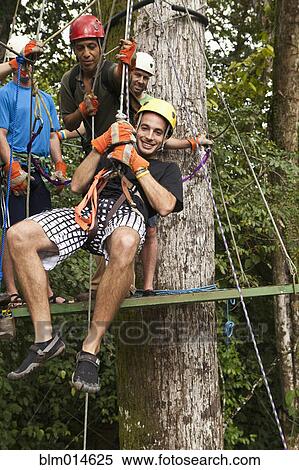 Man being helped onto zip line View Large Photo Image Stock Photography - Man being helped onto zip line. Fotosearch