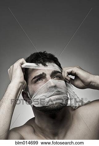 Man removing bandage from his face View Large Photo Image Stock Photo - Man removing bandage from his face. Fotosearch