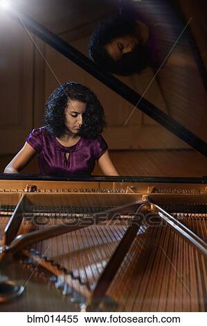 Stock Photography - Middle Eastern woman playing piano. Fotosearch