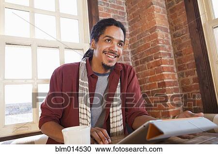 Mixed race man using digital tablet in coffee shop View Large Photo Image Stock Image - Mixed race man using digital tablet in coffee shop. Fotosearch