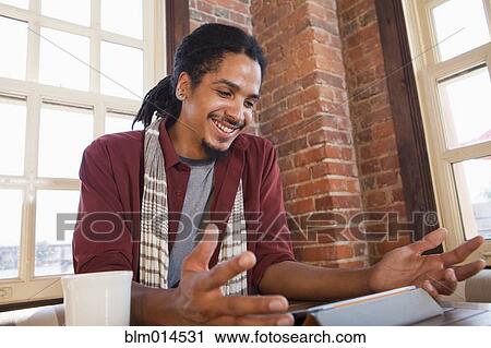 Mixed race man using digital tablet in coffee shop View Large Photo Image Stock Image - Mixed race man using digital tablet in coffee shop. Fotosearch