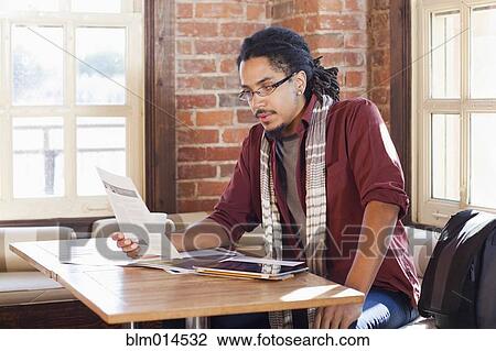 Stock Image - Mixed race man working in coffee shop. Fotosearch