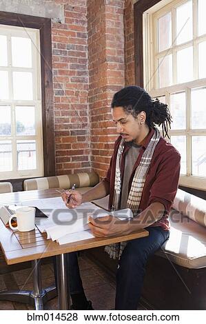 Mixed race man working in coffee shop View Large Photo Image Stock Photo - Mixed race man working in coffee shop. Fotosearch