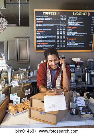 Mixed race man working in coffee shop View Large Photo Image Stock Photo - Mixed race man working in coffee shop. Fotosearch