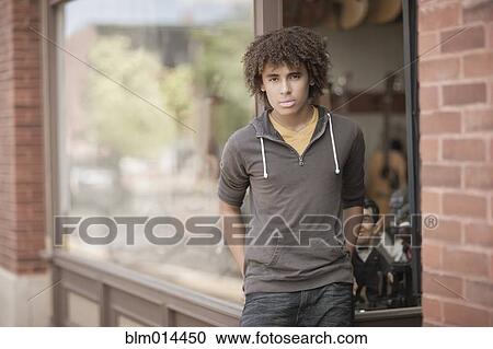 Mixed race teenager standing outside music store View Large Photo Image Stock Image - Mixed race teenager standing outside music store. Fotosearch