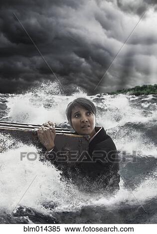 Mixed race woman clinging to trunk in stormy sea View Large Photo Image Stock Photography - Mixed race woman clinging to trunk in stormy sea. Fotosearch
