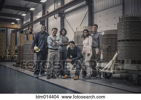 Picture - Workers standing together in factory. Fotosearch