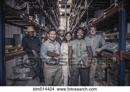 Picture - Workers standing together in factory. Fotosearch