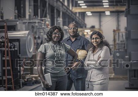 Stock Photo - Workers standing together in factory. Fotosearch