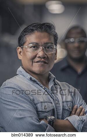 Stock Photo - Workers standing together in factory. Fotosearch