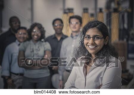 Stock Photo - Workers standing together in factory. Fotosearch