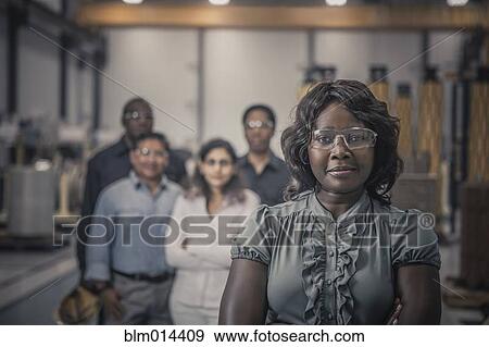 Stock Photo - Workers standing together in factory. Fotosearch