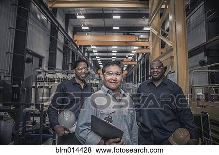 Stock Photo - Workers standing together in factory. Fotosearch