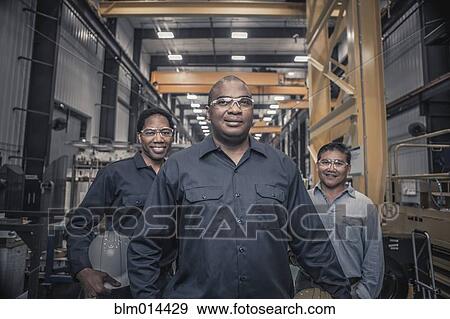 Stock Photo - Workers standing together in factory. Fotosearch