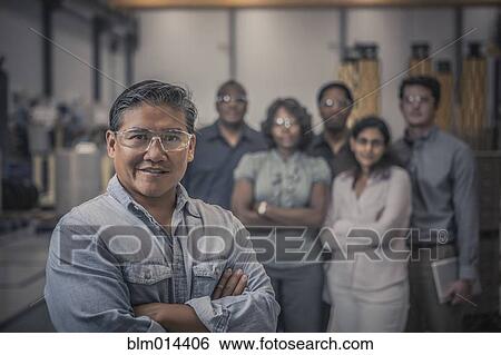 Stock Photograph - Workers standing together in factory. Fotosearch