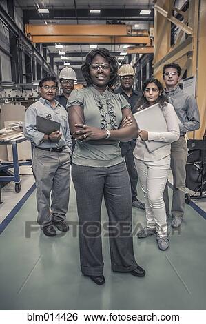 Stock Photograph - Workers standing together in factory. Fotosearch