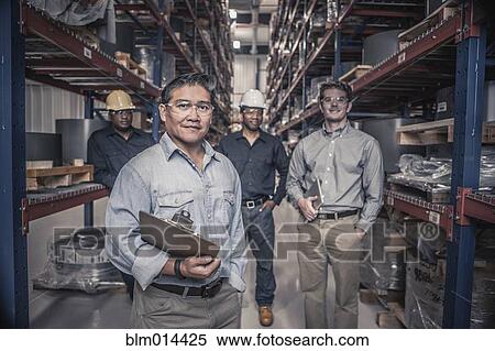 Stock Photography - Workers standing together in factory. Fotosearch