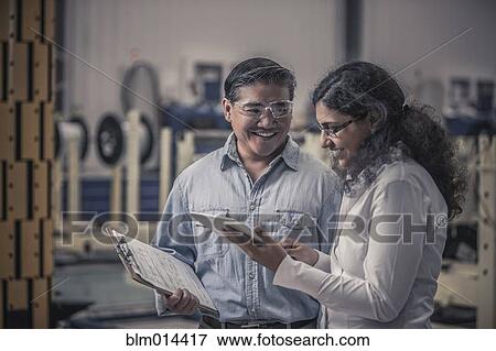 Stock Photo - Workers talking in factory. Fotosearch