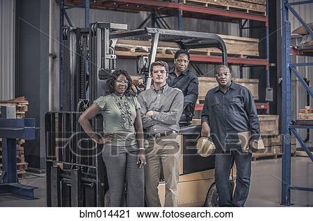 Stock Image - Workers with forklift in factory. Fotosearch
