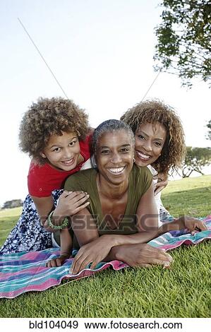 Stock Photo - African American family laying in park. Fotosearch