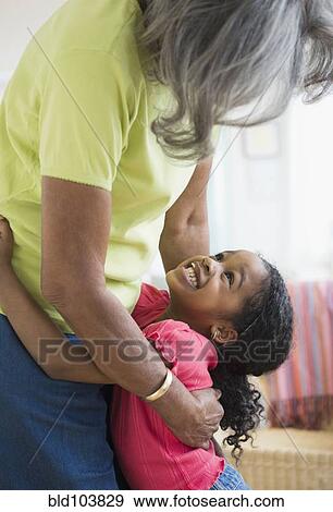Stock Photo - African American grandmother and granddaughter hugging. Fotosearch