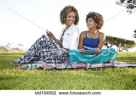 African American mother and daughter using digital tablet in park View Large Photo Image Stock Image - African American mother and daughter using digital tablet in park. Fotosearch