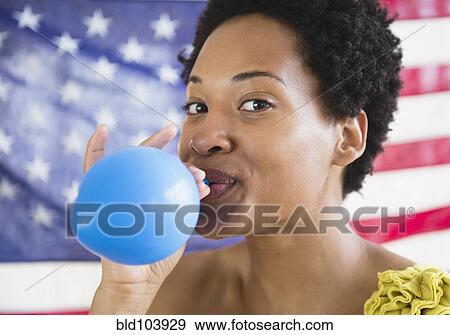 African American woman blowing up blue balloon View Large Photo Image Stock Photo - African American woman blowing up blue balloon. Fotosearch
