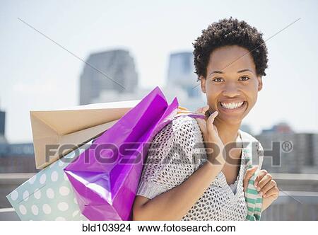 African American woman carrying shopping bags View Large Photo Image Picture - African American woman carrying shopping bags. Fotosearch
