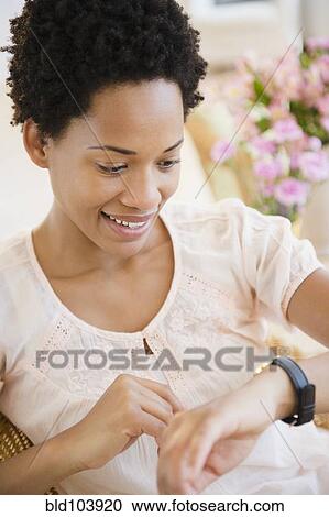 Stock Image - African American woman checking the time. Fotosearch