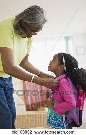 African American woman helping granddaughter with backpack View Large Photo Image Stock Image - African American woman helping granddaughter with backpack. Fotosearch