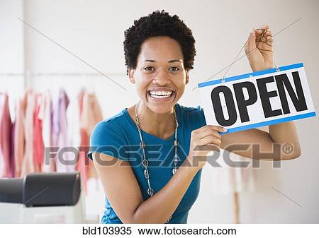 Stock Photography - African American woman holding up open sign. Fotosearch