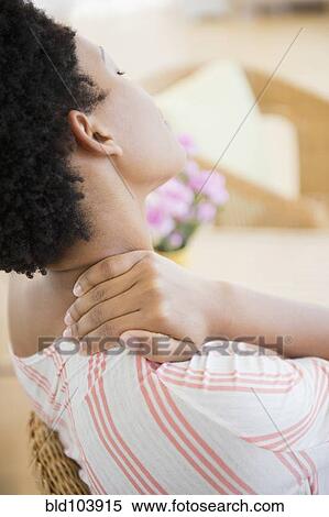 Stock Photography - African American woman rubbing sore neck. Fotosearch