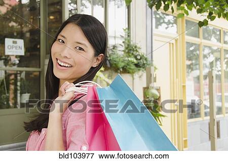 Stock Photo - Asian woman carrying shopping bags. Fotosearch