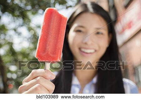 Stock Photo - Asian woman eating popsicle. Fotosearch