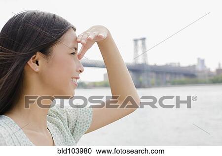 Stock Image - Asian woman looking at urban cityscape. Fotosearch