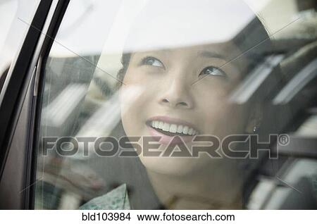 Picture - Asian woman riding in car. Fotosearch