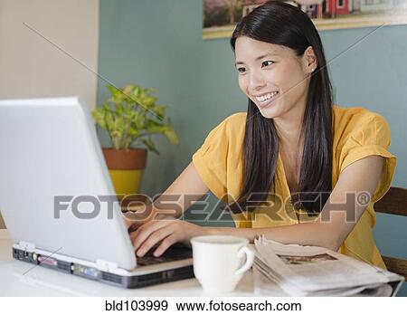 Stock Photo - Asian woman using laptop. Fotosearch