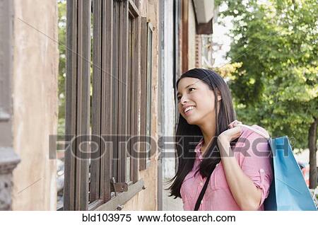 Stock Photography - Asian woman window shopping. Fotosearch