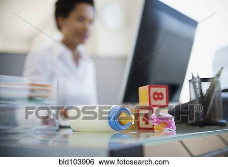 Baby bottle and blocks on African American woman's desk View Large Photo Image Stock Photograph - Baby bottle and blocks on African American woman's desk. Fotosearch