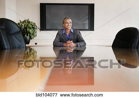 Black businesswoman sitting in empty conference room View Large Photo Image Stock Photo - Black businesswoman sitting in empty conference room. Fotosearch