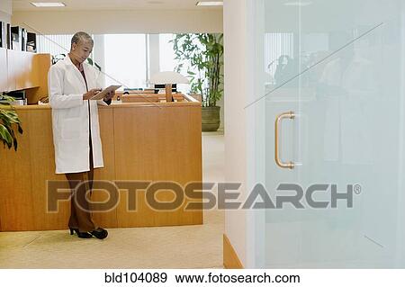 Stock Photo - Black doctor using digital tablet. Fotosearch