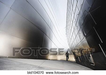 Stock Image - Businessman walking in urban alley. Fotosearch