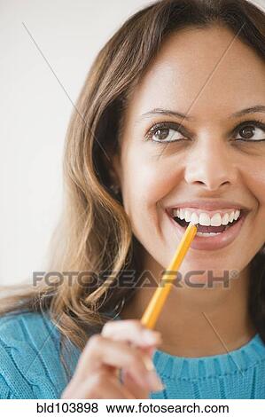 Cape Verdean woman biting pencil View Large Photo Image Stock Photo - Cape Verdean woman biting pencil. Fotosearch