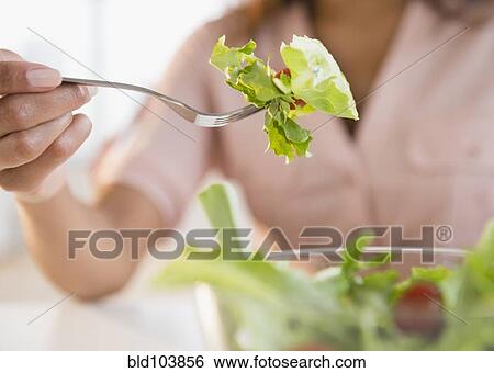 Stock Photograph - Cape Verdean woman eating salad. Fotosearch