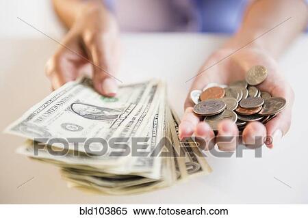 Stock Photography - Cape Verdean woman holding dollar bills and coins. Fotosearch
