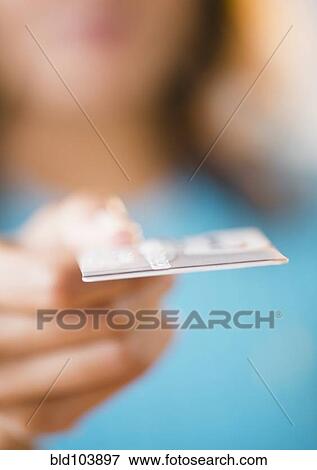 Stock Photo - Cape Verdean woman holding out credit card. Fotosearch