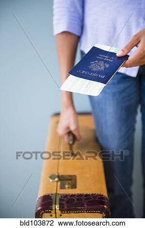 Cape Verdean woman holding passport and suitcase View Large Photo Image Stock Image - Cape Verdean woman holding passport and suitcase. Fotosearch