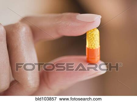 Stock Photo - Cape Verdean woman holding pill capsule. Fotosearch