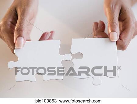 Stock Image - Cape Verdean woman holding puzzle pieces. Fotosearch
