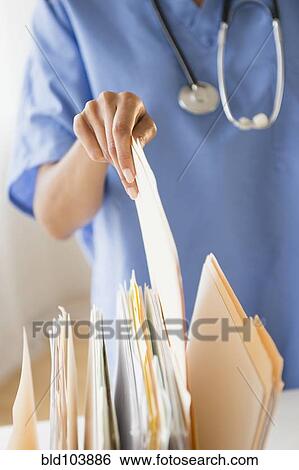 Cape Verdean woman picking up a file folder View Large Photo Image Stock Photograph - Cape Verdean woman picking up a file folder. Fotosearch
